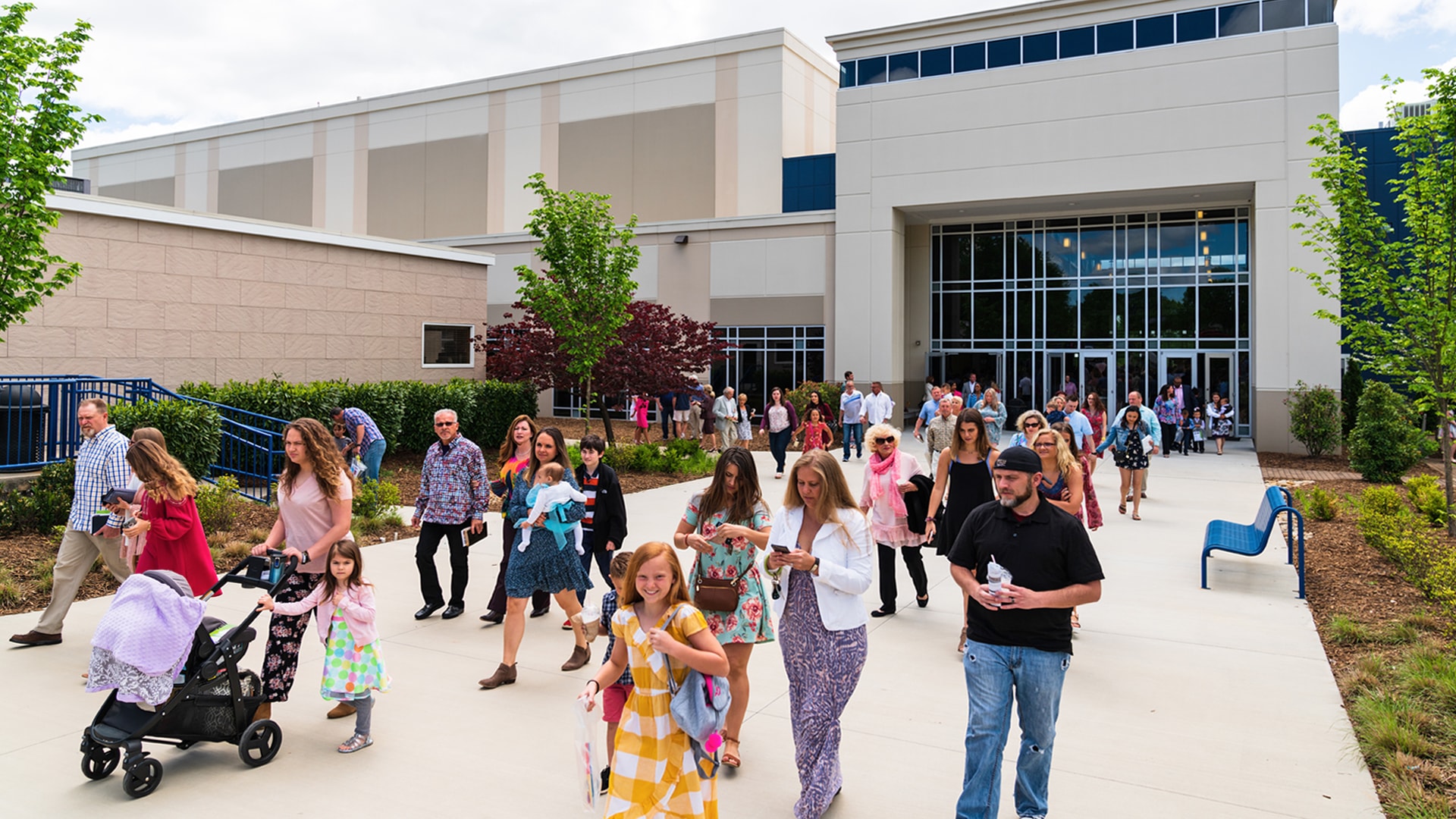 A crowd of all different ages and walks of life leaving the Brookwood Church building after a service